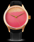 Wristwatch with a black leather strap and a pink and gold watch face on a black background