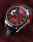 Luxury watch with red face and black leather strap on a dark background Wancher Kaguya AKANE moonphase watch featuring raden mother of pearl artistry