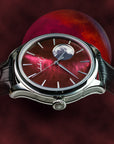 Watch with a red and black design on a dark background side shot of Elegant Wancher moonphase watch with red raden dial inspired by Japanese artistry