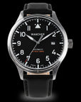Wancher Flugel Automatic Pilot Watch with a black dial and brown perforated leather strap, worn on a wrist against a dark background.