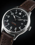A Wancher Flugel Automatic Watch, powered by Miyota 9015, on a wrist. The watch has a dark face with clear white markers and a brown strap.