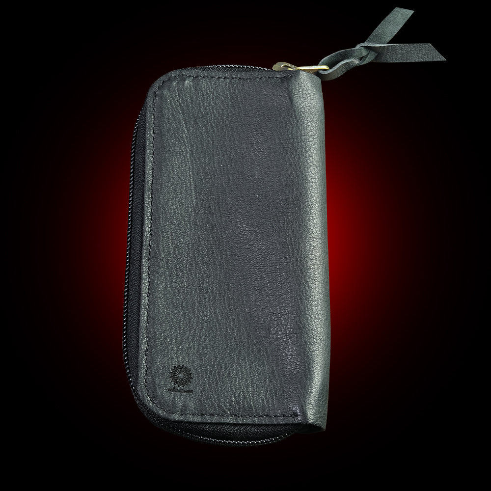 Black leather wallet with a zipper on a dark background Japanese artisanal leather pouch featuring air-beaten and embossed deer leather