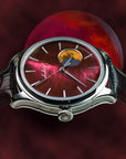 Luxury watch with a detailed face against a dark red background TSUKIMI Gold Moon Disk Dial  Dream Moonphase Kaguya AKANE Wancher Watch  H7M01 Automatic Moonphase Watch 
