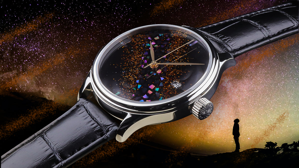 A dream watch raden wancher watch automatic Japanese urushi maki-e watch with a black leather strap and a round silver-toned case, shown prominently against a dramatic starry sky background. The watch face is dark with colorful iridescent square accents and gold-tone hands.
