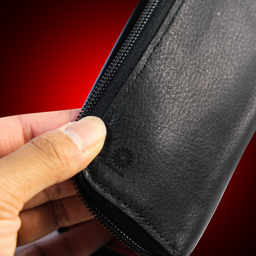 Close-up of a hand holding a black leather wallet with a red background Nakatsu-made luxury deer leather pouch with natural grain and unique texture CAVAN Japan, Wancher watch accessories 