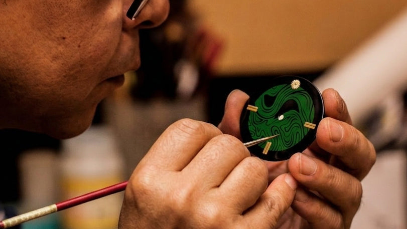 Japanese urushi maki-e artisan hand drawing on an urushi lacquered dial from wajima urushi maki-e 